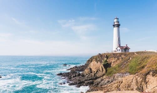 A timeless lighthouse stands tall on a rugged cliff, gazing over the vast ocean - symbolizing the enduring spirit of Ageless Societies